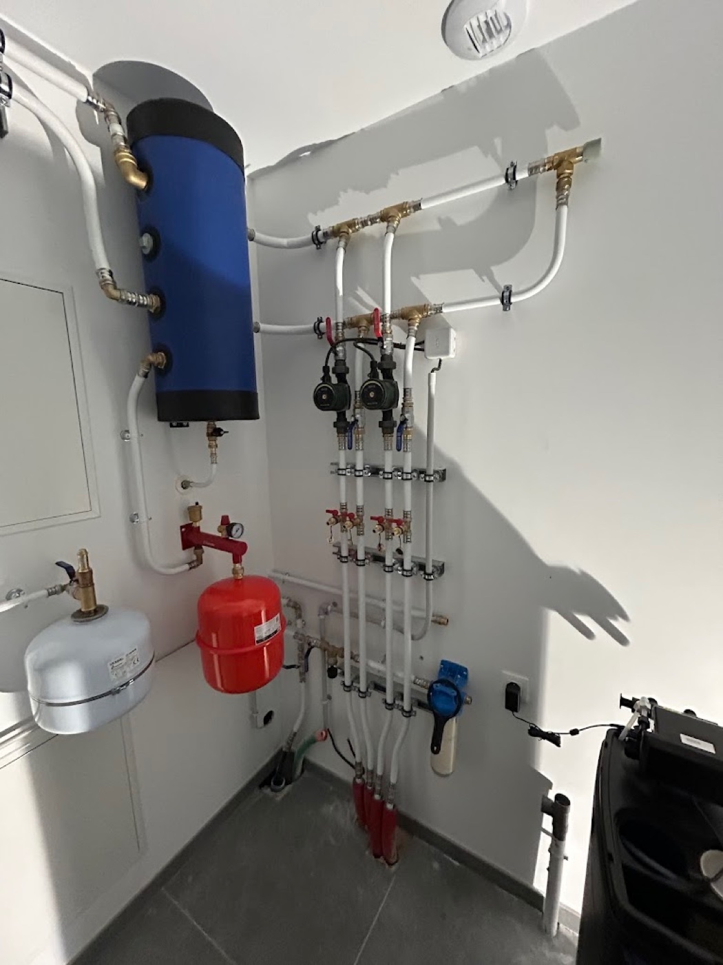 Détail d'une installation : ballon tampon, vase d'expansion, manifold avec circulateurs
